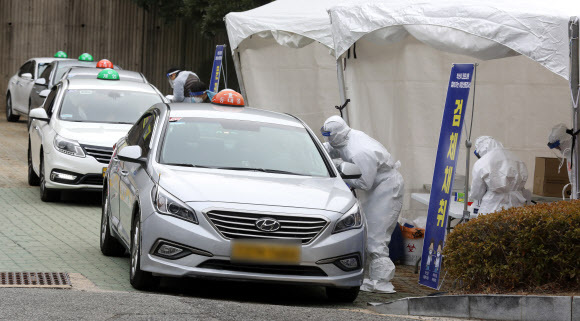 지난 11일 오후 부산 연제구 부산아시아드주경기장 주차장에서 택시 기사들이 드라이브 스루로 신종 코로나바이러스 감염증(코로나19)검사를 받고 있다. 뉴스1