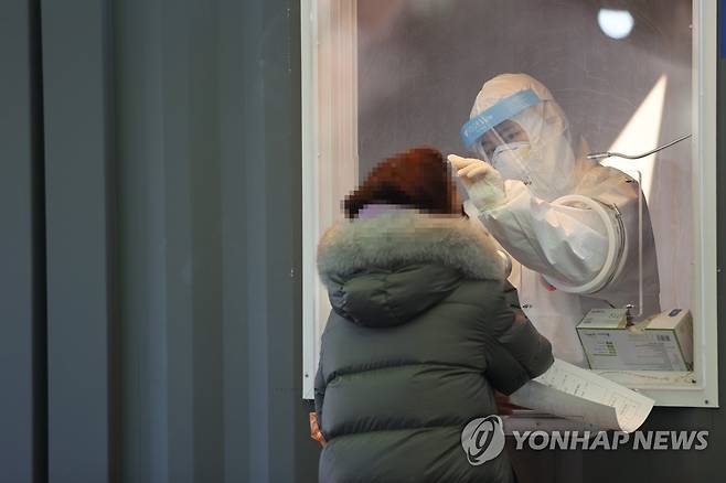 확진자 닷새째 500명대 (서울=연합뉴스) 임화영 기자 = 신종 코로나바이러스 감염증(코로나19) 신규 확진자가 닷새째 500명대를 유지하고 있는 16일 오전 서울역에 마련된 임시선별진료소에서 의료진이 검체채취를 하고 있다. 2021.1.16 hwayoung7@yna.co.kr