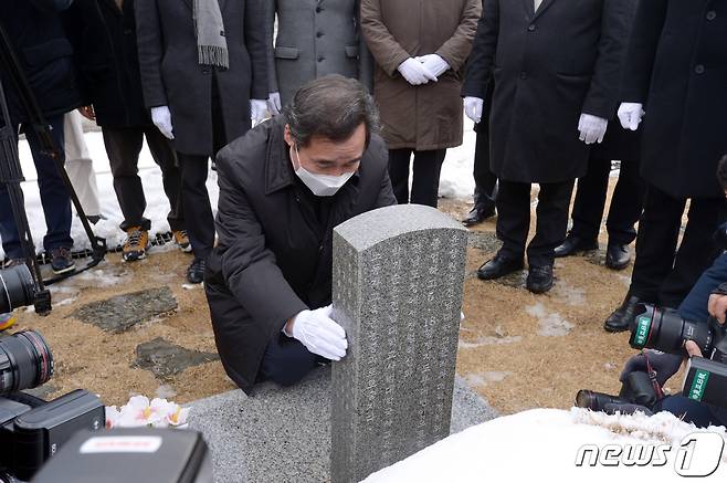 이낙연 더불어민주당 대표가 18일 오후 광주 북구 운정동 국립5·18민주묘지에서 참배를 마친 뒤 윤상원 열사 묘비를 잡고 무릎을 꿇고 있다.2021.1.18 /뉴스1 © News1 정다움 기자