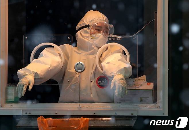 18일 오후 서울역 앞 광장에 마련된 신종 코로나바이러스 감염증(코로나19) 임시선별진료소에서 의료진이 함박눈을 바라보며 생각에 잠겨 있다. 질병관리청 중앙방역대책본부에 따르면 이날 0시 기준 코로나19 신규 확진자는 389명 발생했다. 300명대로 줄어든 것은 지난 11월 25일 이후 54일만이다. 2021.1.18/뉴스1 © News1 김진환 기자