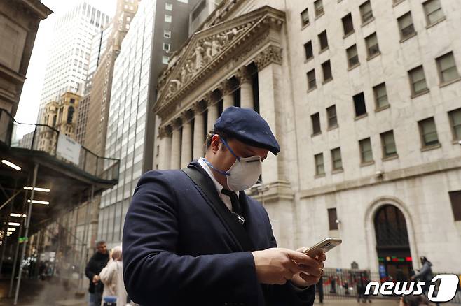 뉴욕 증권거래소 앞에서 한 남자가 스마트폰을 보고 있다.© 로이터=뉴스1