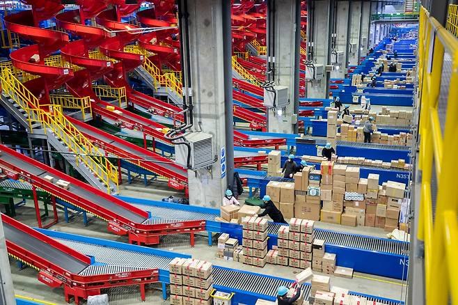 롤러코스터 같은 벨트 타고 쏟아지는 박스 - 지난 15일 밤 국내 최대 무인 물류센터인 CJ대한통운 메가허브 곤지암에서 AI 컨베이어벨트가 행선지별로 무인 자동 분류한 택배를 직원들이 트레일러에 싣고 있다. 이날 밤 이곳에선 택배 170만 상자가 트레일러 800대에 실려 수도권 각지로 떠났다. /이태경 기자