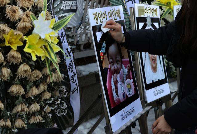 서울 양천구 남부지방법원 청사 앞에 놓인 정인 양의 사진이 담긴 패널 앞에서 정인 양을 추모하는 시민. 연합뉴스