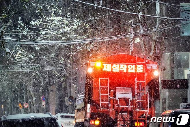 서울에 많은 눈이 내린 6일 오후 홍대입구역 인근에 눈이 쌓이자 제설차량이 염화칼슘을 뿌리고 있다. 2020.1.6/뉴스1 © News1 황덕현 기자