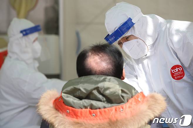 국내 신종 코로나바이러스 감염증(코로나19) 확진자 첫 발생 1년을 맞은 20일 대구 달서구 두류공원 임시선별검사소에서 의료진이 진단검사를 위해 방문한 시민의 검체를 채취하고 있다. 2021.1.20/뉴스1 © News1 공정식 기자
