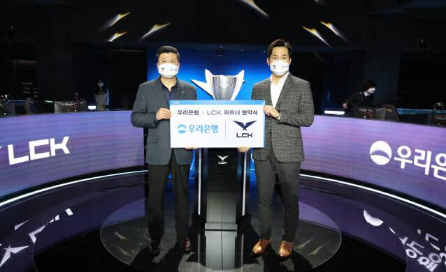 우리은행은 지난 19일 서울 종로구 롤파크에서 ‘리그 오브 레전드 챔피언스 코리아(LCK)’와 파트너 계약을 체결했다. 권광석(사진 왼쪽) 우리은행장과 오상헌 LCK 대표가 기념촬영을 하고 있다.(사진=우리은행)