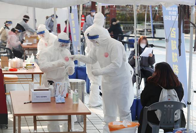 22일 오후 부산 연제구 부산시청 등대광장에 마련된 코로나 임시 선별검사소에서 의료진들이 분주히 움직이고 있다.  /김동환 기자