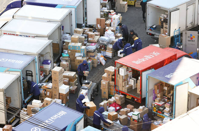 Parcel delivery workers move boxes Tuesday ahead of the Lunar New Year holiday next month. Unionized delivery workers are mulling to launch a full-scale walkout in their fight for better working condition and wages. (Yonhap)