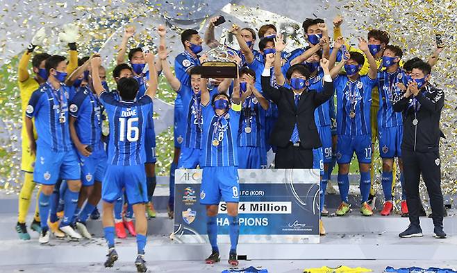 울산 현대 선수단이 지난달 카타르 도하에서 열린 2020 아시아축구연맹 챔피언스리그(ACL)에서 우승을 차지한 뒤 트로피를 들고 환호하고 있다. 도하=AP뉴시스