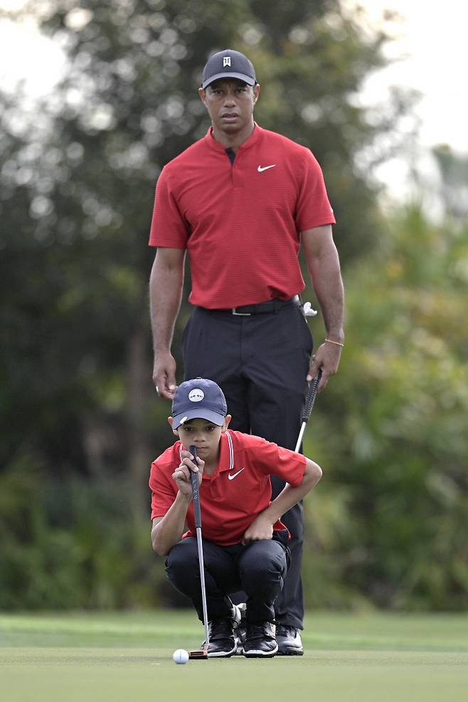 타이거 우즈가 지난달 열린 PNC 챔피언십서 아들 찰리와 함께 퍼팅 라인을 보고 있다.AP|연합뉴스