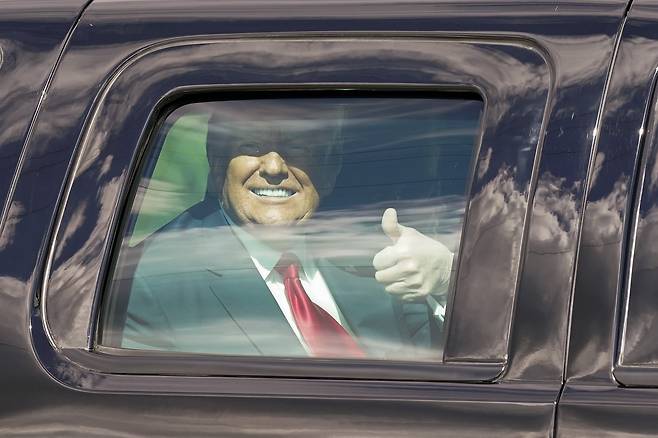 플로리다에 도착한 트럼프 대통령이 자신 소유의 마라라고 리조트로 행하는 자동차 안에서 지지자들을 향해 엄지를 치켜들고 있다. AP=연합뉴스