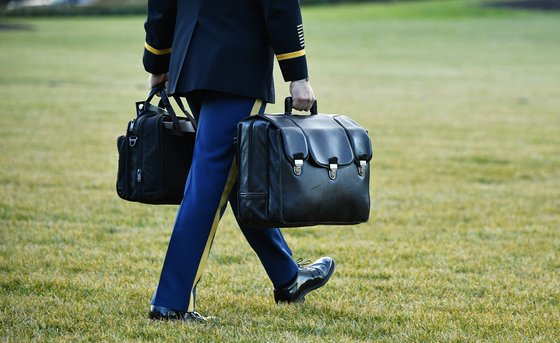20일(현지시간) 도널드 트럼프 전 미국 대통령이 백악관을 떠나기 전, 장교가 핵가방을 대통령 전용 헬기에 운반하고 있다. 정면에 보이는 가방이 핵가방이다. [AFP]