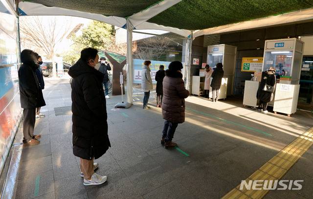 [대구=뉴시스] 이무열 기자 = 지난 20일 오전 대구 동구 보건소 코로나19 선별진료소에서 시민들이 검체 채취를 하기 위해 줄을 서 있다. 2021.01.20. lmy@newsis.com