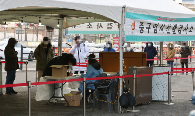 지난 20일 오전 서울역 광장에 마련된 코로나19 임시선별진료소에서 시민들이 기다리고 있다./연합뉴스