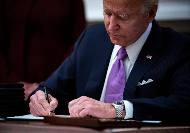 조 바이든 미국 대통령이 취임 이튿날인 21일 코로나19 대응 관련 브리핑을 열고 행정명령에 서명하고 있다. 워싱턴=EPA 연합뉴스