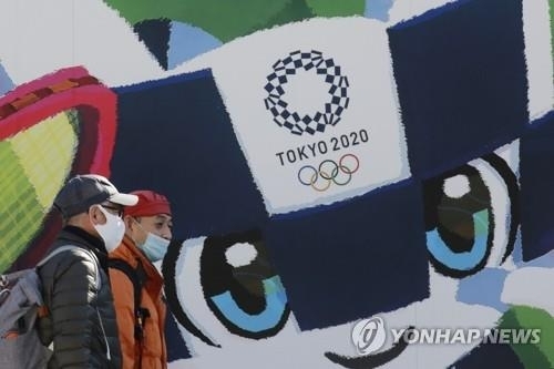 (도쿄 AP=연합뉴스) 지난 19일 도쿄 시내의 올림픽·패럴림픽 홍보 포스터 앞을 행인들이 지나가고 있다.
