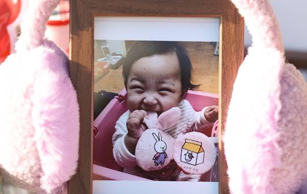 경기도 양평 하이패밀리 안데르센 공원묘지에 안장된 정인양의 묘지에 귀마개로 감싸진 정인양 사진이 놓여있는 모습. [연합]