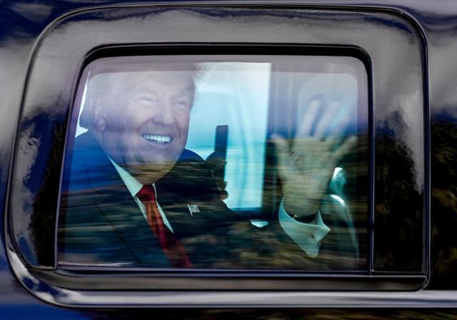 도널드 트럼프 전 미국 대통령이 20일 플로리다주 마러라고리조트로 향하는 차량 안에서 지지자들에게 웃으며 손을 흔들고 있다. 웨스트팜비치=AP 연합뉴스