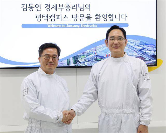 2018년 8월 6일 김동연(왼쪽) 경제부총리 겸 기획재정부 장관과 이재용 삼성전자 부회장이 경기 평택시 삼성전자 평택캠퍼스 내 반도체 공장 라인을 둘러본 후 악수하고 있다. 연합뉴스