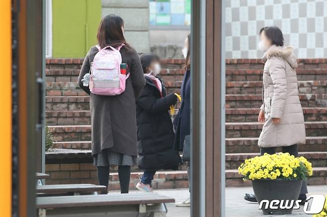 (서울=뉴스1) 송원영 기자 = 수도권 사회적 거리 두기가 2단계로 격상된 24일 오후 서울의 한 초등학교에서 어린이들이 하교하고 있다. 이날부터 고등학교를 제외한 유치원, 초·중학교 등교 인원 3분의 1로 제한된다. 학생들은 일주일에 1~2일만 학교에 가거나 학년별로 3주마다 돌아가면서 등교해야 한다. 2020.11.24/뉴스1  <저작권자 ⓒ 뉴스1코리아, 무단전재 및 재배포 금지>