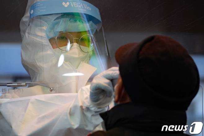 (서울=뉴스1) 이재명 기자(서울=뉴스1) 이재명 기자 = 신종 코로나바이러스 감염증(코로나19) 국내 첫 감염자가 발생한지 1년째인 20일 오전 서울 중구 서울역광장에 마련된 임시선별검사소에서 의료진이 검체검사를 하고 있다. 2021.1.20/뉴스1  <저작권자 ⓒ 뉴스1코리아, 무단전재 및 재배포 금지>
