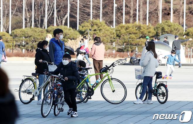 전국 대부분 지역의 기온이 영상권에 머문 24일 오후 서울 송파구 올림픽공원 세계평화의 문 광장에서 시민들이 자전거를 타고 있다. 2021.1.24/뉴스1 © News1 김진환 기자