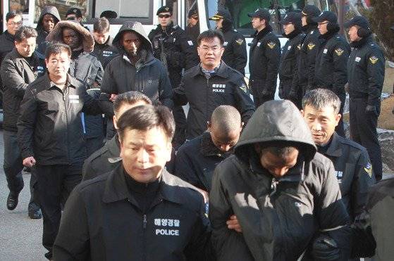 2011년 1월 30일 삼호주얼리호를 납치했다가 청해부대에 의해 생포된 해적 5명이 부산으로 압송됐다. 항공편으로 도착한 해적들은 부산지법에서 영장실질심사를 받은 뒤 수사본부가 있는 남해해양경찰청으로 들어가고 있다. [중앙포토]