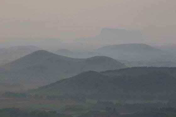 해 뜰 무렵 다랑쉬오름에 올라 찍은 동부 오름 군락. 능선을 따라 삼나무가 서 있는 맨 앞의 오름이 손자봉이고, 손자봉 뒤로 여러 겹의 곡선이 겹쳐진 언덕이 용눈이오름이다. 멀리 성산일출봉도 보인다. 손민호 기자