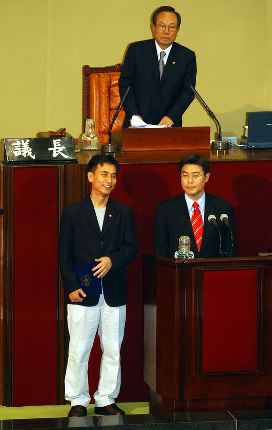 고양 덕양갑 재선에서 당선한 유시민 개혁당 의원(左)이 2003년 4월 29일 캐주얼 차림으로 국회 본회의에 등원해 선서를 하려 하자 일부 의원이 복장을 문제삼아 선서가 불발되는 촌극이 빚어졌다.