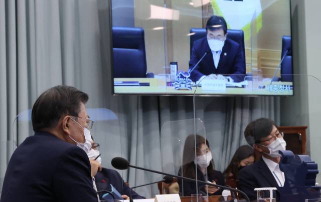 문재인 대통령이 25일 오후 청와대에서 열린 복지부·식약처·질병청 2021년 업무보고에 참석, 권덕철 보건복지부 장관 보고를 받고 있다./연합뉴스