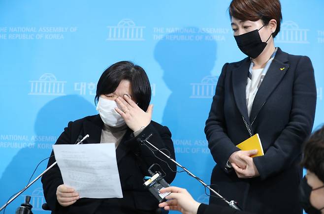 정의당 젠더인권본부장인 배복주 부대표(왼쪽)가 25일 국회 소통관에서 김종철 대표의 성추행 사건 관련 긴급기자회견 도중 눈물을 닦고 있다. 오른쪽은 정호진 대변인. /연합뉴스
