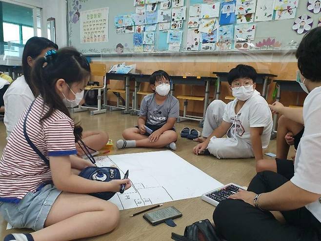 지난해 ‘참 좋은 놀이터’ 조성사업에 참여한 울산 영화초등학교 학생들이 교사와 함께 수업시간을 활용해 각자 생각하는 놀이터 설계안에 관한 얘기를 나누고 있다. 울산시교육청 제공