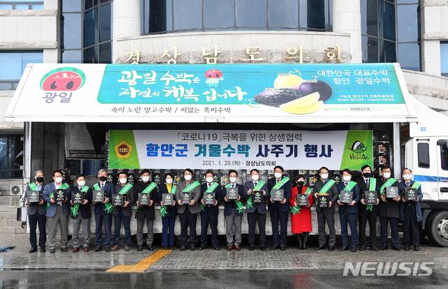 [창원=뉴시스] 홍정명 기자= 26일 경남도의회 광장에서 열린 '함안 겨울수박 사주기 행사' 참석자들이 수박을 들고 기념촬영을 하고 있다.(사진=경남도의회 제공) 2021.01.26. photo@newsis.com