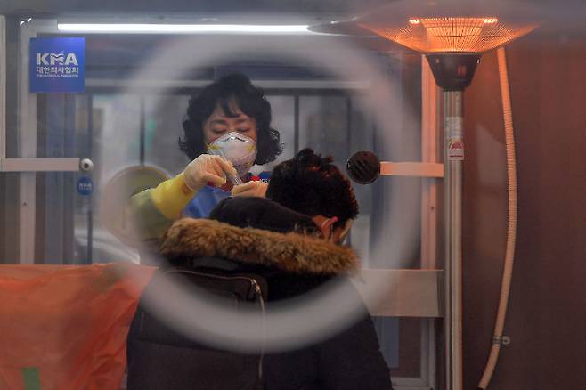 전세계 코로나19 누적 확진자가 1억명을 넘어선 것으로 집계된 26일 서울광장 임시선별검사소에서 의료진이 검체를 채취하고 있다. 박종민 기자