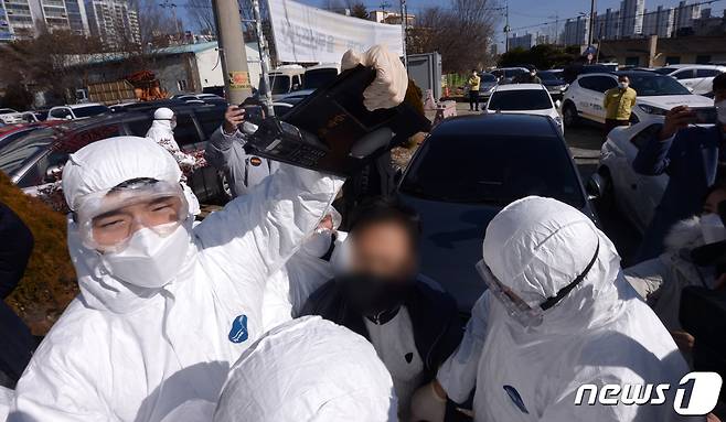 27일 오후 광주 광산구 TCS국제학교 앞에서 한 시민이 건물 외벽에 계란을 던지려고 해 경찰의 제지를 받고 있다.2021.1.27/뉴스1 © News1 정다움 기자