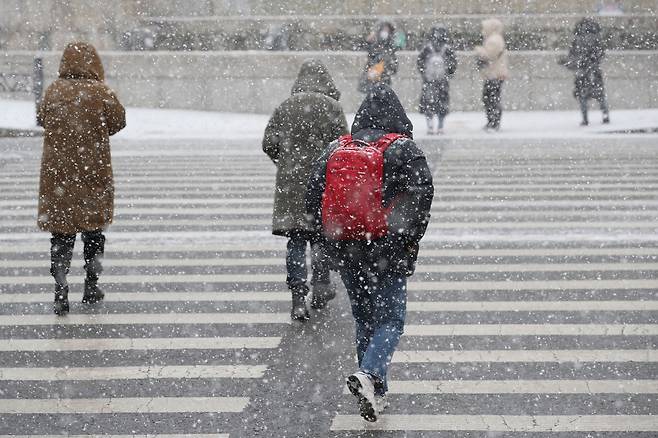눈이 내렸던 지난 18일 오전 서울 중구 한국은행 앞 교차로에서 시민들이 횡단보도를 건너고 있다.  /뉴시스