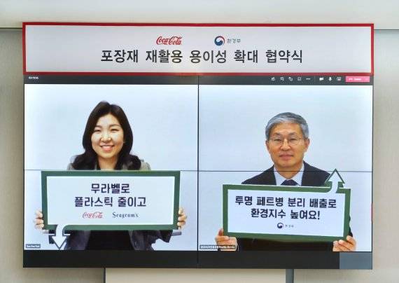 최수정 한국코카콜라 대표(왼쪽)와 김영훈 환경부 자연환경정책실장이 포장재 재활용 용이성 확대를 위한 협약식을 체결한 뒤 기념촬영을 하고 있다.