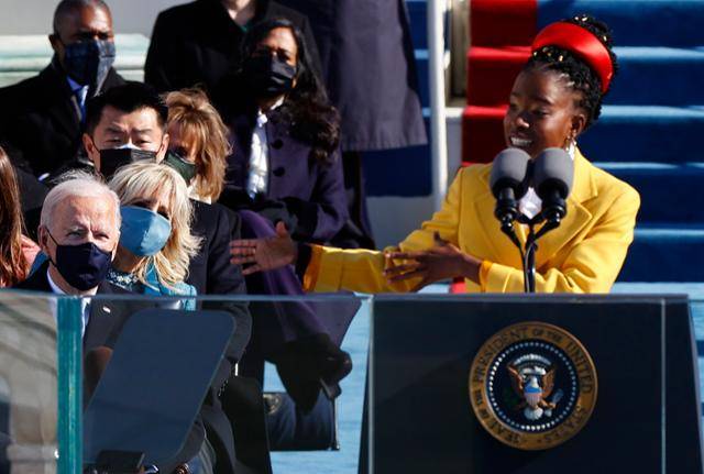 아만다 고먼이 20일(현지시간) 미 의회 의사당에서 열린 제46대 미국 대통령 취임식에서 조 바이든 대통령(왼쪽) 앞에서 축시를 낭송하고 있다. 그는 자작시 ‘우리가 오르는 언덕’에서 미국의 통합과 치유, 희망을 노래했다. 워싱턴=로이터 연합뉴스