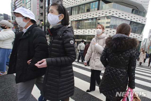 [도쿄=AP/뉴시스]지난 26일 일본 도쿄의 긴자 쇼핑거리에서 코로나19 예방을 위해 마스크를 쓴 시민들이 건널목을 건너고 있다. 2021.01.26.