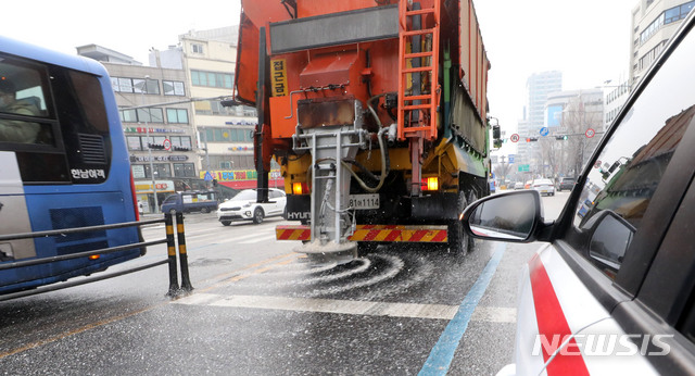 [서울=뉴시스]박주성 기자 = 눈이 내리는 18일 오전 서울 도로에 제설차량이 염화칼슘을 뿌리고 있다. 2021.01.18. park7691@newsis.com