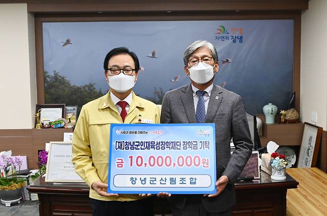 26일 창녕군산림조합 김성기 조합장(오른쪽)이 (재)창녕군인재육성장학재단 한정우 이사장에 장학금 1000만원을 기탁하고 기념촬영을 하고 있다.&copy;창녕군