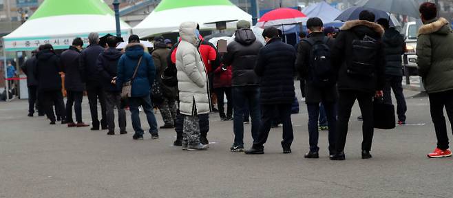 26일 서울역광장에 설치된 임시선별진료소에서 시민들이 검사시작을 기다리며 줄을 서 있다. 연합뉴스