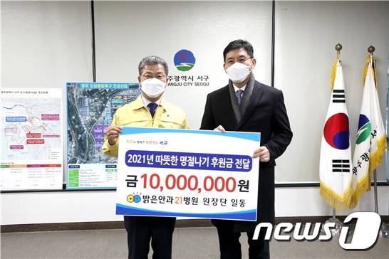 밝은안과21병원 윤길중 대표원장(오른쪽)이 서대석 광주 서구청장(왼쪽)에게 ‘2021년 따뜻한 명절나기 후원금' 1000만원을 전달하고 기념촬영을 하고 있다. 2021.1.28 © 뉴스1