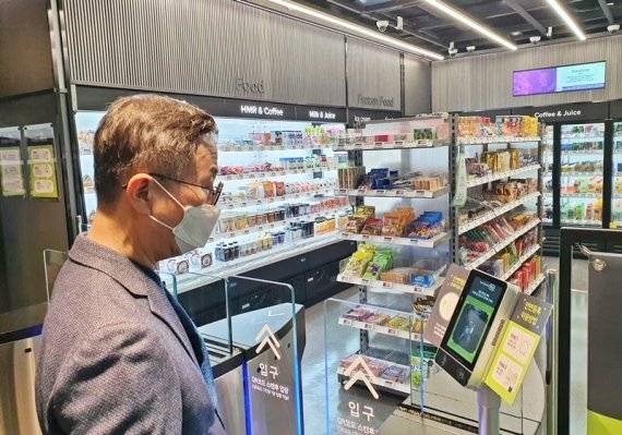 BGF리테일 이건준 사장이 '테크 프렌들리(Tech Friendly) CU' 1호점인 CU삼성바이오에피스점에서 안면 인증 출입시스템을 이용하고 있다. CU 제공