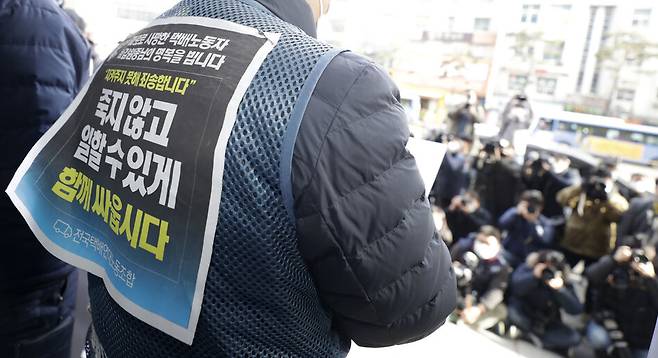 27일 오후 서울 중구 한진택배 본사 앞에서 전국택배노동조합 조합원들이 총파업 돌입 기자회견에 ‘죽지 않고 일할 수 있게 함께 싸웁시다’라고 적힌 조끼를 입고 참석하고있다. 김혜윤 기자 unique@hani.co.kr