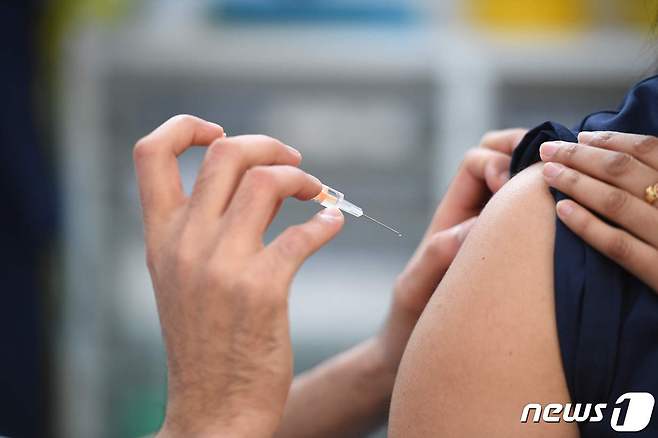 영국의 백신 접종 센터에서 한 여성이 코로나19 백신을 맞고 있다. © AFP=뉴스1