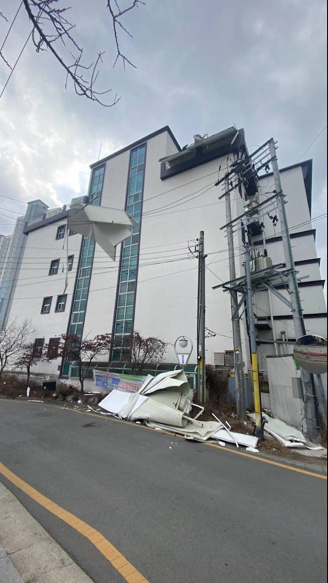 28일 오후 대구지역에 강풍이 불며 대구 동구 괴전동의 한 전봇대 전깃줄에 바람에 날아온 패널이 걸려 있다. 연합뉴스