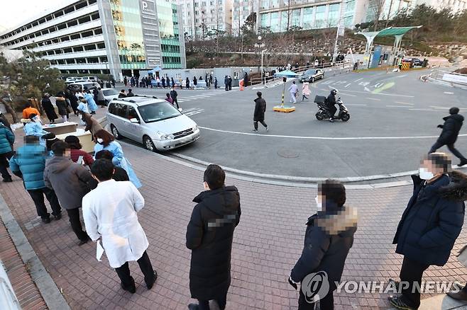 한양대병원 선별진료소 인근 검사 대기줄 (서울=연합뉴스) 윤동진 기자 = 신종 코로나바이러스 감염증(코로나19) 확진자가 나온 서울 한양대병원 선별진료소 주변이 검사 대기자들로 붐비고 있다. 2021.1.29 mon@yna.co.kr