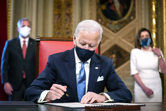 U.S. President Joe Biden signs three documents including cabinet nominations at the Capitol after his inauguration as the 46th president on Jan. 20. [UPI/YONHAP]