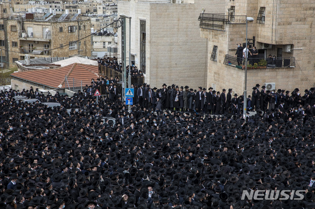 [예루살렘=AP/뉴시스] 31일 예루살렘에서 수천 명의 초정통 유대교 신도들이 코로나 19에도 불구하고 랍비의 장례식 행렬에 참석해 행진하고 있다